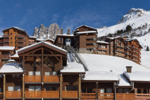 um alojamento de esqui nas montanhas com neve nos telhados em RESIDENCE OLYMPIE 1 em Méribel