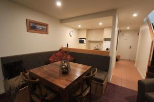 a dining room with a table and a couch at Thredbo 31 in Thredbo