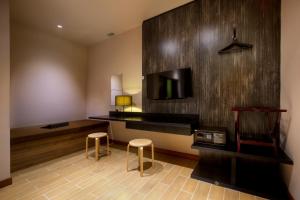 a room with two stools and a tv and a wall at Hotel Twenty 8B in Kuala Lumpur