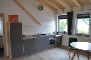 a kitchen with gray cabinets and a table and window at Beim Hooch "Drien" in Brücktal