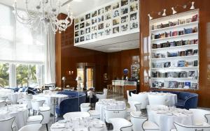 una sala da pranzo con tavoli e sedie bianchi e un lampadario a braccio di Miami Icon Brickel Luxury Condo a Miami
