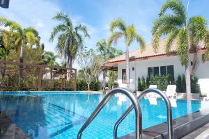 a swimming pool at a resort with palm trees at Nisasiri Boutique Resort in Laem Sing