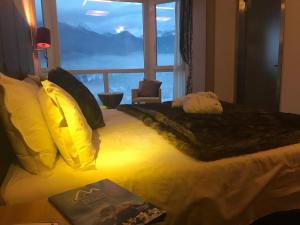 a bedroom with a bed with a large window at Antelao Dolomiti Mountain Resort in Borca di Cadore