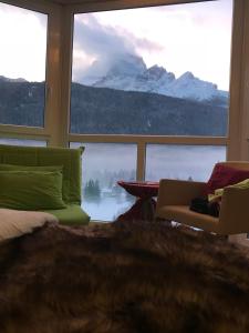 sypialnia z dużym oknem z widokiem na góry w obiekcie Antelao Dolomiti Mountain Resort w mieście Borca di Cadore