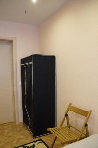 a black refrigerator in the corner of a room at Хостел Обской возле Толмачево in Ob