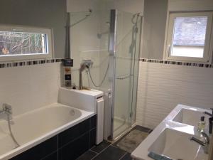 a bathroom with a tub and a shower and a sink at La maison de Brijy in Pleslin-Trigavou