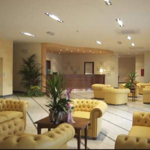 a lobby with yellow couches and a waiting room at Hotel Conteverde in Montecchio Emilia