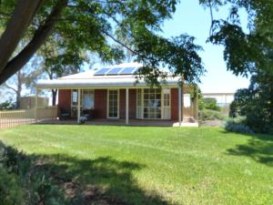 a house with a solar roof and a yard at Glenbar cottage Yelta in Mildura