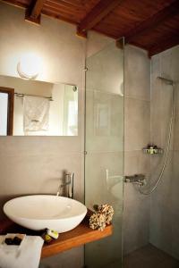 a bathroom with a sink and a glass shower at Archontiko Stathopoulou in Agios Georgios Nilias