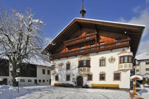 a large building with a roof in the snow at Gasthaus Kammerhof in Angath