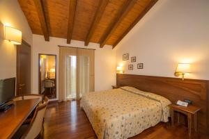 1 dormitorio con cama, mesa y escritorio en Hotel Conteverde, en Montecchio Emilia