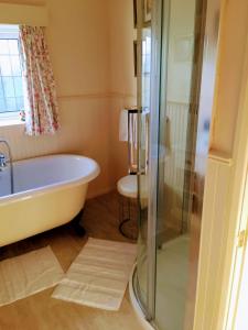 un baño con bañera y ducha en Grove House Bed & Breakfast, en York 23 fotos más