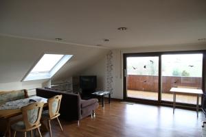 a living room with a couch and a table with chairs at Ferienwohnung Panoramaweg in Sohren