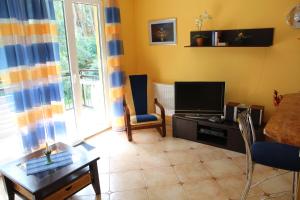 een woonkamer met een televisie en een tafel en stoelen bij Apartment Jola in Pobierowo