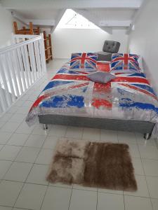 - une chambre avec un lit et un tapis à un étage dans l'établissement Joli T2 à 5 min de la plage, au Gosier