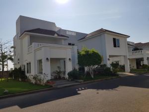 a large white house on a street at Elysium Kovalam in Chennai