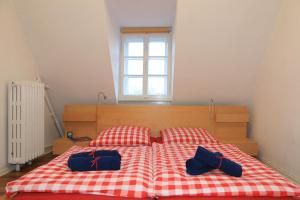 ハーメルンにあるFerienwohnung INSELVILLAのベッド1台(赤と白のチェック入り毛布、青の袋2つ付)