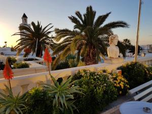 a statue of a woman on a building with palm trees at Maison d'Hôtes Dar Ennassim in La Marsa