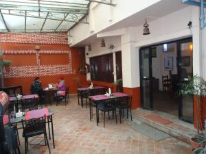 a restaurant with tables and chairs and people sitting at Hotel Earth House in Kathmandu