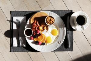 a plate of breakfast food with eggs and fruit at Canary Riverside Plaza Hotel in London