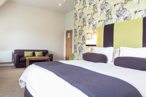 een hotelkamer met een groot bed en een bank bij The Green House in Bournemouth