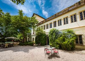 a building with chairs and a table in front of it at El Asiento Del Azar in Banyeres del Penedes