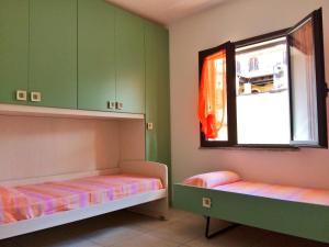 トルトリにあるCopernico's new apartmentのベッド2台と窓が備わる客室です。