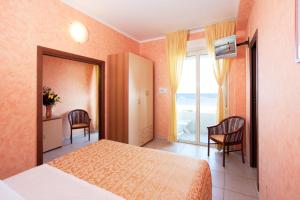 a bedroom with a bed and a view of the ocean at Hotel Caesar in Cesenatico