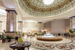 a lobby with a large building with a ceiling at Melas Lara Hotel in Lara