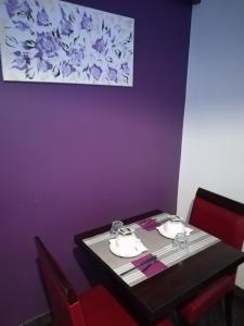 uma mesa de jantar com cadeiras e uma parede roxa em Hotel du Globe 18 em Paris