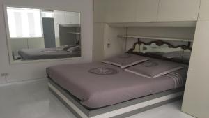 een slaapkamer met 2 bedden en een grote spiegel bij Vista mare in Viareggio