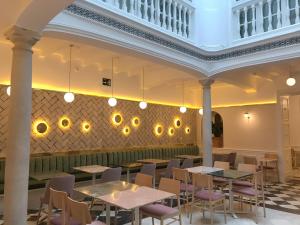 a restaurant with tables and chairs and a ceiling at Halo Boutique Hotel in Seville