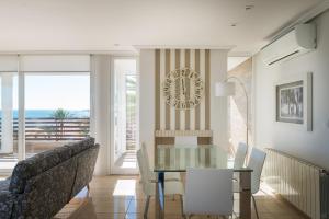 comedor con mesa de cristal y sillas en Apartamentos Marta PLAYA, en Alicante