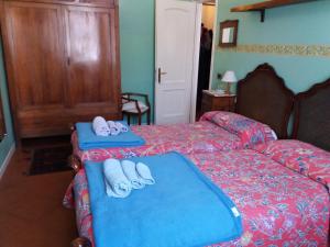 una camera d'albergo con due letti e pantofole di B&B "Angela " a Piacenza