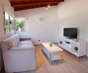 a living room with a couch and a tv at Altos del Rio (Solo parejas) in Los Reartes