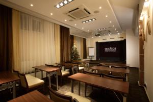 a restaurant with tables and chairs and a projection screen at Business Hotel Senator in Yekaterinburg