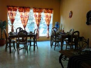 a dining room with tables and chairs and a window at Hostal Doña Marta in San Salvador +6 photos