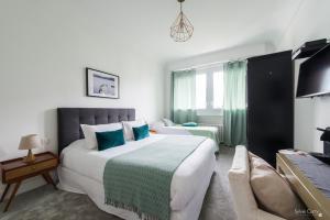 Cette chambre comprend un grand lit et un canapé. dans l'établissement Villa Verde La Rochelle, à La Rochelle