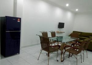 a dining room with a glass table and chairs at CityScape Lodge - Penginapan Bajet yang Mudah, Selesa & Selamat dengan WiFi dan Parkir PERCUMA Serta Layanan Mesra Tambah Servis Memuaskan in Lumut +3 photos