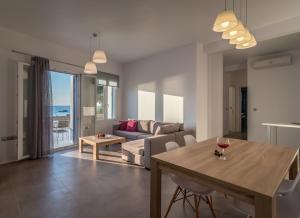 a living room with a table and a couch at Milos Waves Luxury Apartments in Pollonia