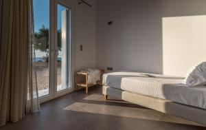 a bedroom with a bed and a large window at Milos Waves Luxury Apartments in Pollonia