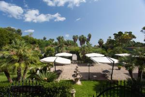 a patio with white umbrellas and a fountain at Hotel Villa d'Amato in Palermo