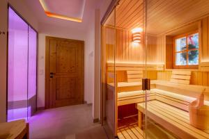 a sauna with a glass door in a room at Tennerhof Luxury Chalets in Kitzbühel