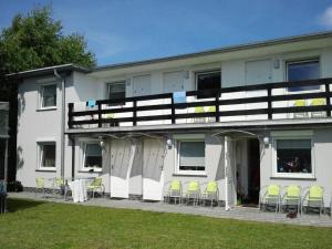 格里兹鲍Pokoje na wynajem "GRZYBOWO"的一座白色的建筑,前面设有椅子和桌子