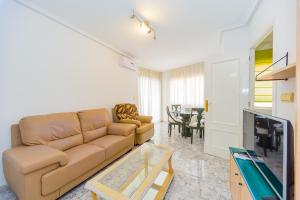 ein Wohnzimmer mit einem Sofa und einem TV in der Unterkunft ALEGRIA ID38 in Torrevieja