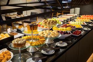 a counter filled with lots of different types of pastries at Meliá Brasil 21 in Brasília