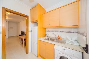 a kitchen with a sink and a washing machine at ALEGRIA ID51 in Orihuela Costa