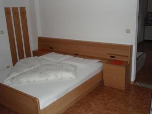 1 dormitorio con 1 cama con cabecero de madera en Klaus Prettau, en Predoi