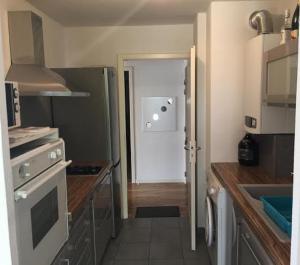 una cocina con una puerta que conduce a una cocina con fogones en Résidence Le Parc COLMAR en Colmar