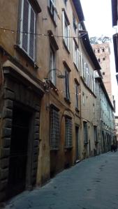 an alley with an old building and a street at Liberi Mercanti - guest house affittacamere in Lucca